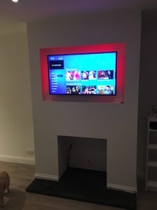 Remote control colour change led light strip makes a feature of the TV recess